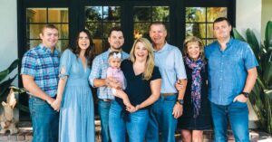 Four generations of a family smiling and posing together.