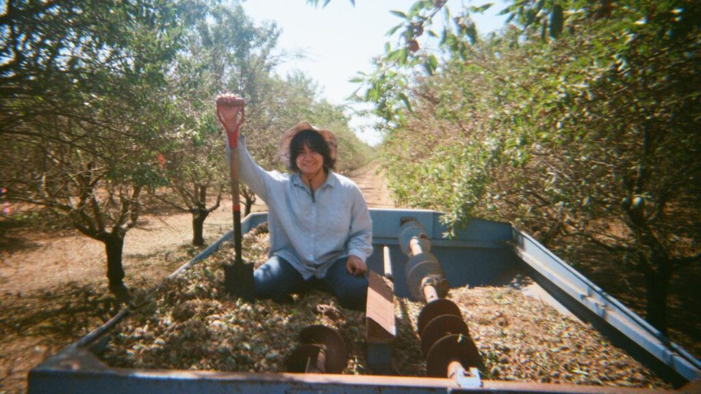 Woman farmer sitting in an orchard truck.
