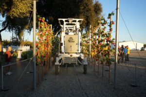 White robotic aq equipment in between rows of vertical crops.