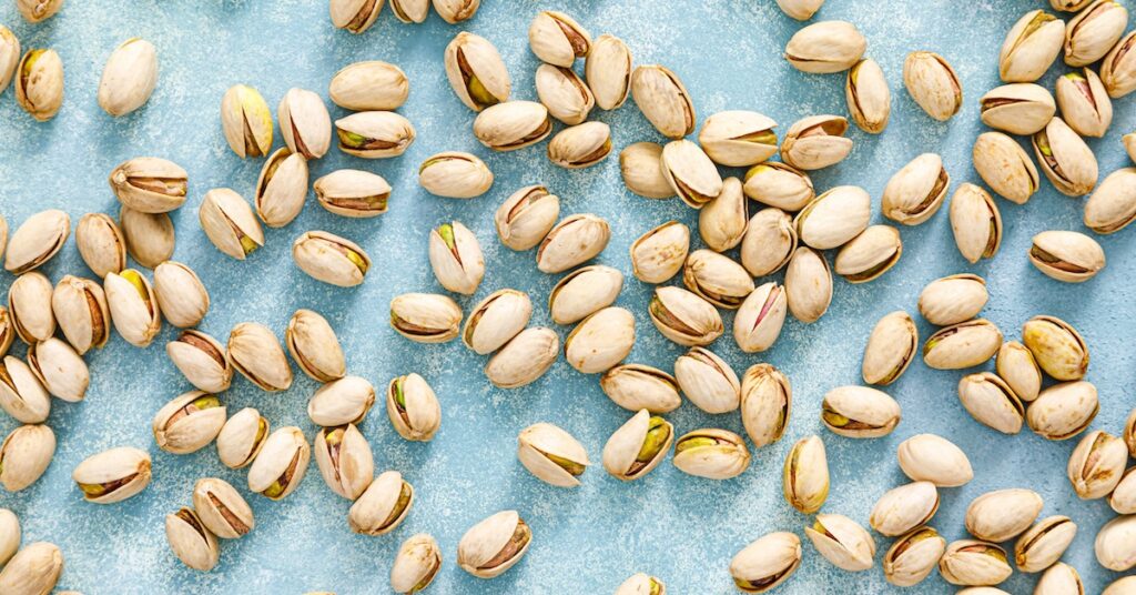 Pistachio nuts on light blue background.
