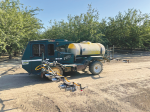 An autonomous farm machine driving in an orchard.