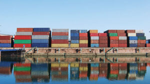 Cargo container in a harbor with water reflections.