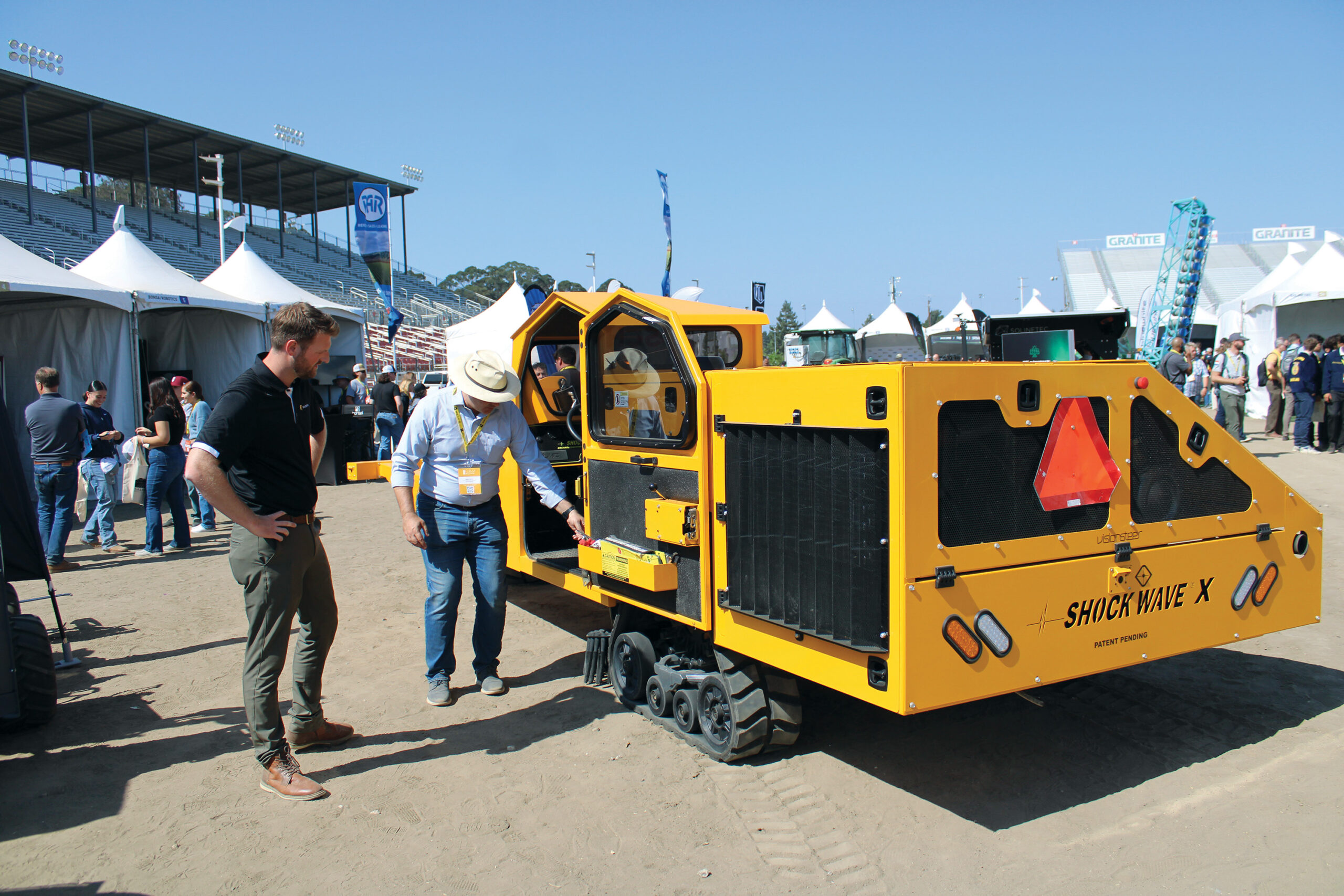 Machinery that collects fruits and nuts that can’t be shaken onto the ground on display at a trade show.