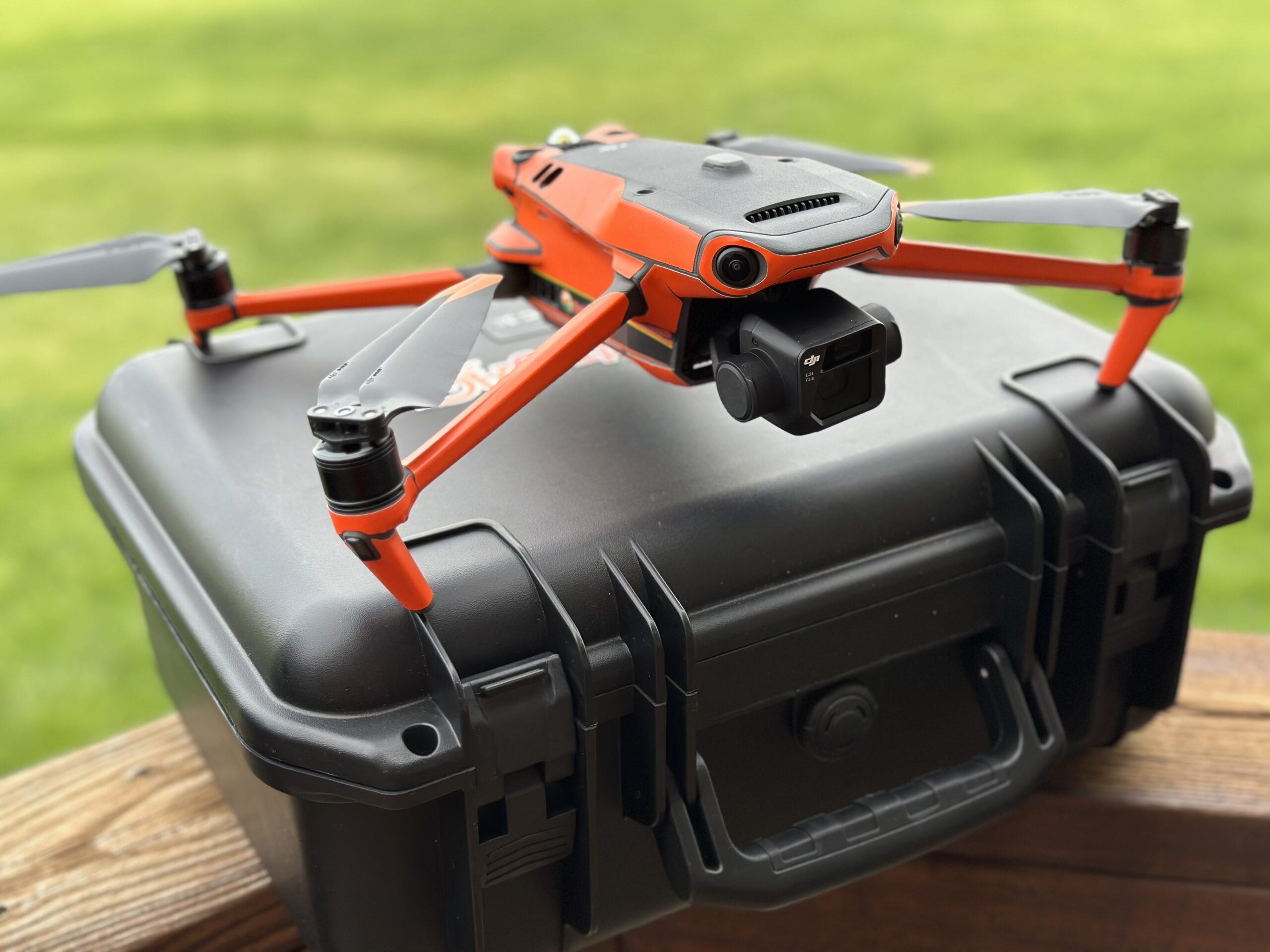 Red drone resting on top of a black carrying case.