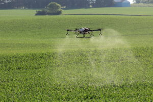 Drone spraying chemicals on a farm field.