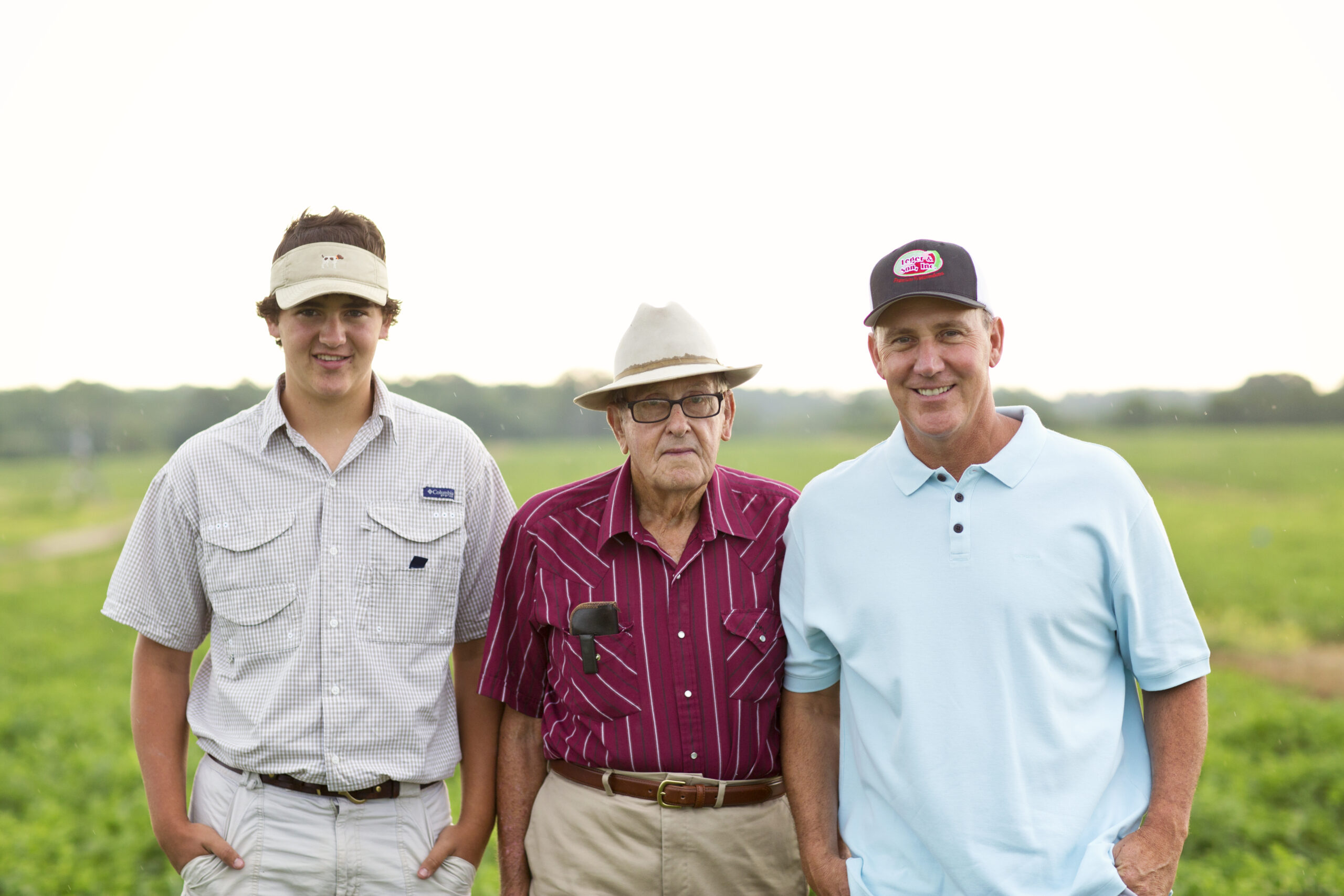 Cole, Buddy and Greg Leger posing together in a field.