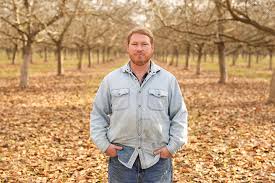 Daniel Unruh of Unruh Walnut Farms standing in a nut tree orchard.