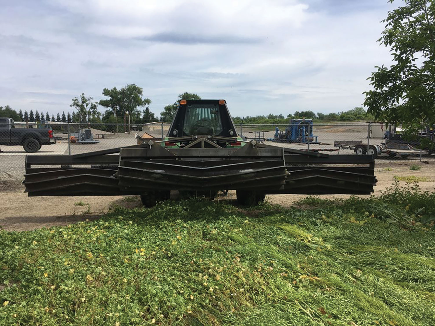 A large piece of farm equipment with a cloudy sky in the background.