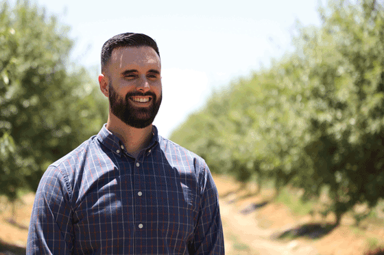 smiling man in almond orchard